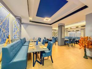 a restaurant with tables and chairs and a large blue ceiling at Zip By Spree Hotels Surabi International Vellore in Vellore