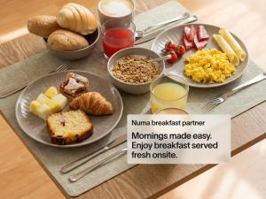 a table with plates of breakfast food on it at Numa Rome Barberini in Rome