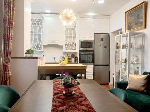 a kitchen with white cabinets and a wooden table at Bed and Breakfast in Old Town in Naujoji Akmenė +5 photos