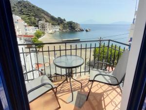 a balcony with a table and chairs and the ocean at Lydia Mare in Agios Kirykos