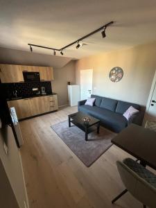 a living room with a blue couch and a kitchen at Minimalist apartment - Lier center in Lier