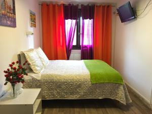 Hotel Paris Star في فيلوجويف: غرفة نوم مع ستائر ملونة وسرير
