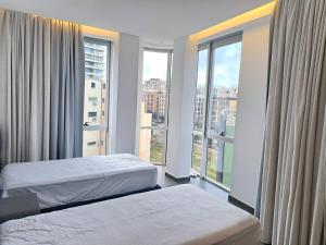 a hotel room with two beds and a large window at SAIFI Apartments in Beirut
