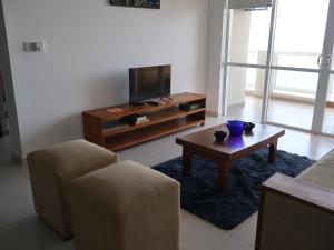 a living room with a tv and a coffee table at Beach Front 2 by A & A Villas in Uswetakeiyawa