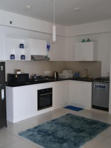 a kitchen with white cabinets and a rug in it at Beach Front 2 by A & A Villas in Uswetakeiyawa