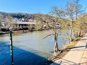 a river next to a sidewalk next to a river at Riverside Cabin Surrounded by Nature for Two in Esneux