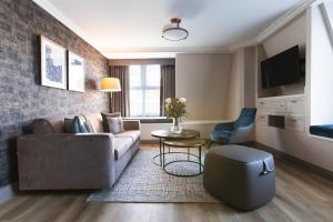 a living room with a couch and a table at The Rathbone Hotel, Fitzrovia in London