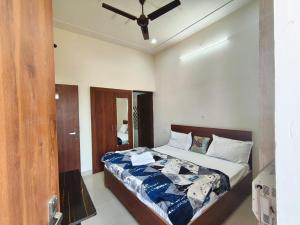 a bedroom with a bed with a ceiling fan at Harigarh Inn in Alīgarh
