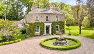 an estate with a fountain in front of a house at The Priory Cottage in Legbourne