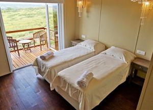 two beds in a hotel room with a balcony at El Abrazo de las Sierras in Minas