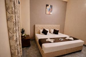 a bedroom with a bed with shoes on it at Hotel Sai 9 Heaven A Quality Apartment Perfect for Families in Shirdi