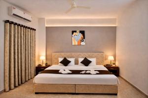 a bedroom with a large bed with two white towels at Hotel Sai 9 Heaven A Quality Apartment Perfect for Families in Shirdi