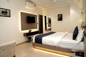 ein Hotelzimmer mit Bett und Fernseher in der Unterkunft hotel the perfect in Ahmedabad