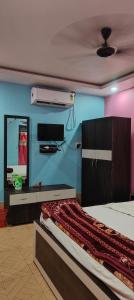 a bedroom with a bed and a tv on the wall at Hotel Mainak Mandarmoni in Mandarmoni
