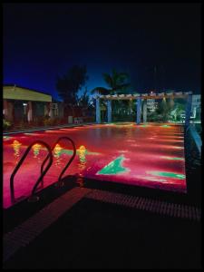 a pool with red and pink lights at night at Hotel Mainak Mandarmoni in Mandarmoni
