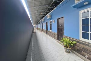an empty corridor of a building with blue walls and a hallway at Sultan Guest House in Palu