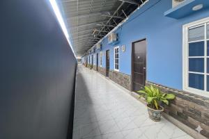 an empty corridor of a building with blue walls and a hallway at Sultan Guest House in Palu +7 photos
