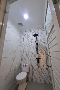 a bathroom with a toilet and a cross on the wall at Sultan Guest House in Palu