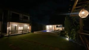 a night view of a house with a swimming pool at Recanto dos Coraiss in Marau