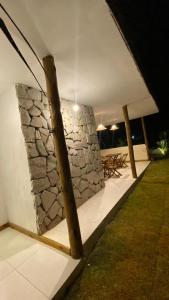 a building with a stone wall and a table at Recanto dos Coraiss in Marau +2 photos