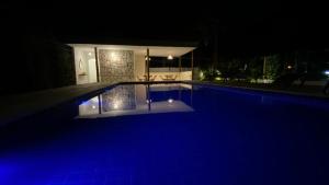 a swimming pool at night with blue illumination at Recanto dos Coraiss in Marau