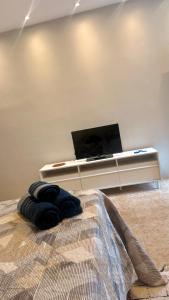 a bedroom with a bed with a flat screen tv at Studio de Hóspedes - 150m da Praia in Rio de Janeiro