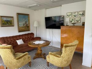 ein Wohnzimmer mit Sofa, Tisch und Stühlen in der Unterkunft Vita huset at Stora Le in Ed
