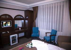 a hotel room with a bed and two blue chairs at Golden Pen Hotel in Istanbul