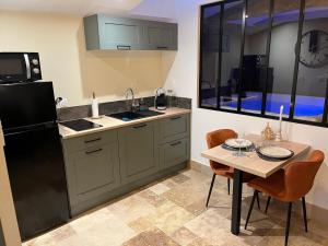 a kitchen with a black refrigerator and a table at La Merletière in Cholet +13 photos