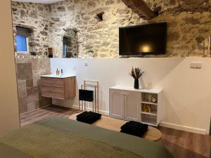 a bedroom with a bed and a tv on the wall at La Merletière in Cholet