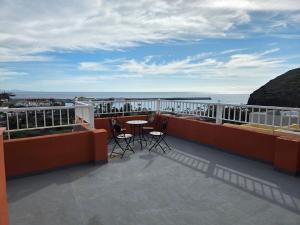 a balcony with a table and chairs and the ocean at apartamentos la villa in San Sebastián de la Gomera