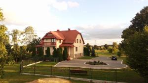 Kołaki WietrzychowoAgroturystyka Pod Jodłami的路上有车的房子