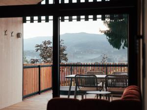 a balcony with tables and chairs and a view of a mountain at Hapfn Tiny Houses mit Hot Tub in Eibiswald