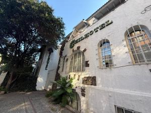 a white building with windows and a tree next to it at Chilhotel en Providencia in Santiago
