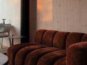 a red couch sitting in a room with a table at Hapfn Tiny Houses mit Hot Tub in Eibiswald