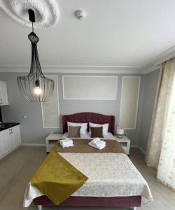 a bedroom with a large bed and a chandelier at Adonis 204 in Zlatibor