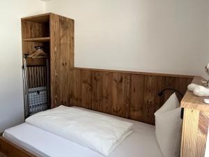 a bedroom with a bed with a wooden headboard at Mountain River Apartment in Chienes