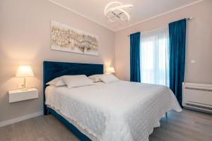 a bedroom with a large white bed with blue curtains at Villa Luna Luxury apartment in Skradin +34 photos
