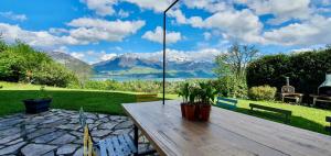 a wooden table with a view of a lake and mountains at Les Eaux Vives in Sévrier