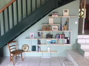 a staircase with a book shelf and a table and a chair at Les Eaux Vives in Sévrier