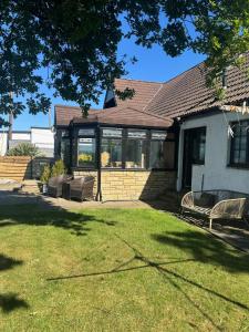 a house with a conservatory with a grass yard at Sea View House in Dalkeith