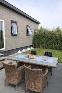 a table and chairs on a patio next to a house at Chalet SOL Y MAR in Renesse