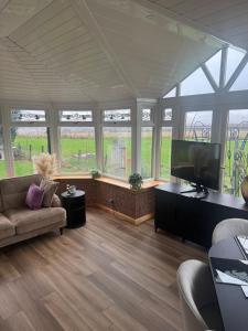 a living room with a couch and a flat screen tv at Sea View House in Dalkeith