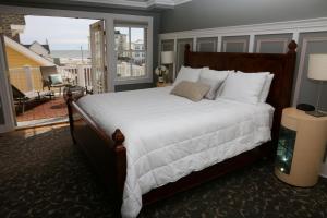 a bedroom with a large bed and a balcony at The Ocean Plaza Hotel in Ocean Grove