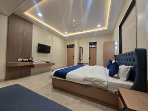 a bedroom with a large bed and a tv at Hotel Shree Karni Palace in Kishangarh