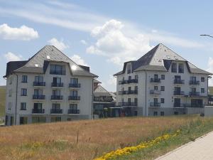 two large buildings in a field next to a building at Adonis 204 in Zlatibor