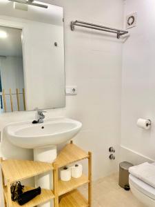 a bathroom with a sink and a mirror at Loft Manuel Arellano in Seville +4 photos