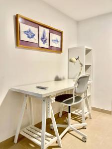a white desk with a lamp and a chair at Loft Manuel Arellano in Seville