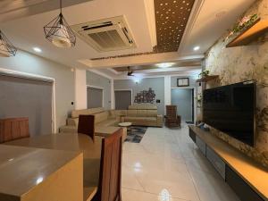 a large living room with a table and a couch at Evania Pool Suites in Nedumbassery