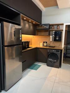 a kitchen with a stainless steel refrigerator and a dishwasher at Evania Pool Suites in Nedumbassery